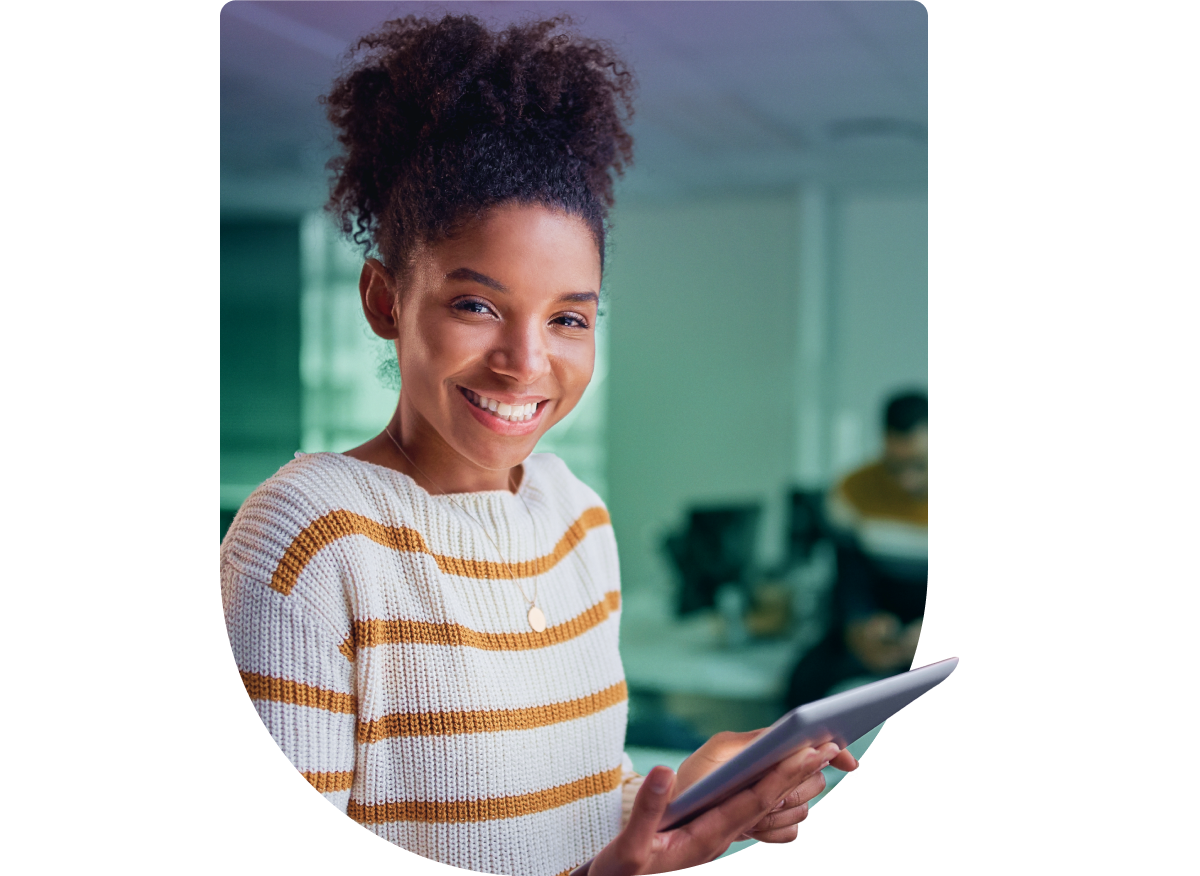 a young girl smiles while holding a tablet