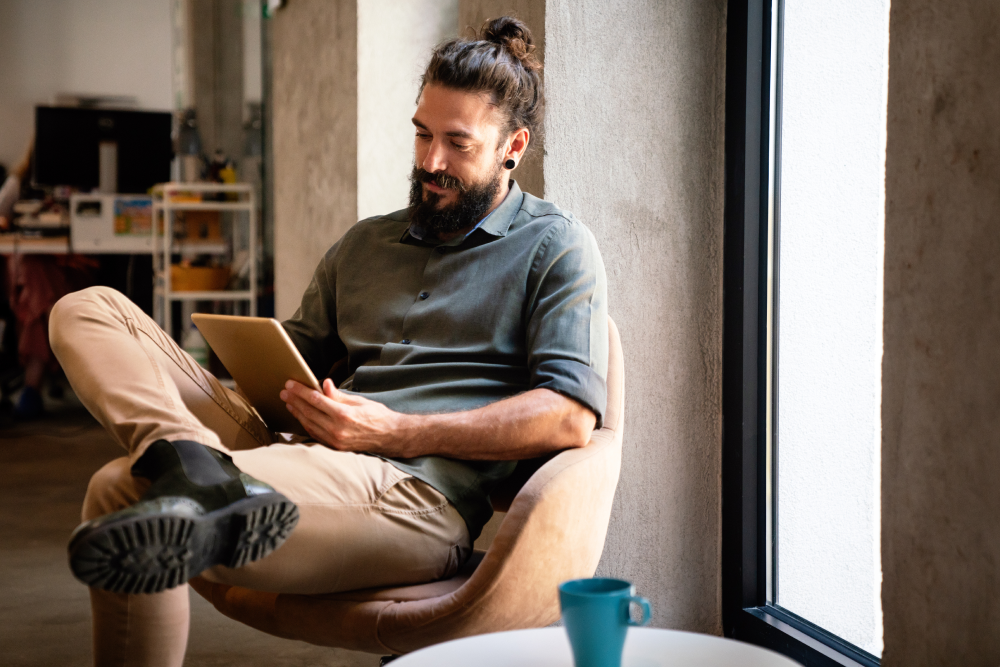 a man sitting on a chair with a tablet