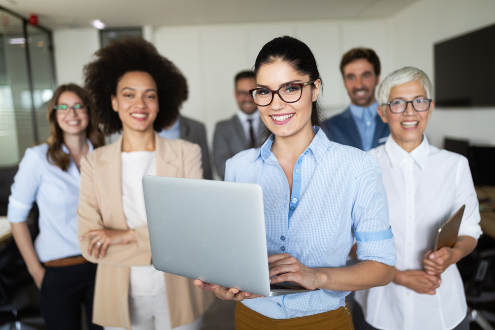 a group of people standing around a laptop