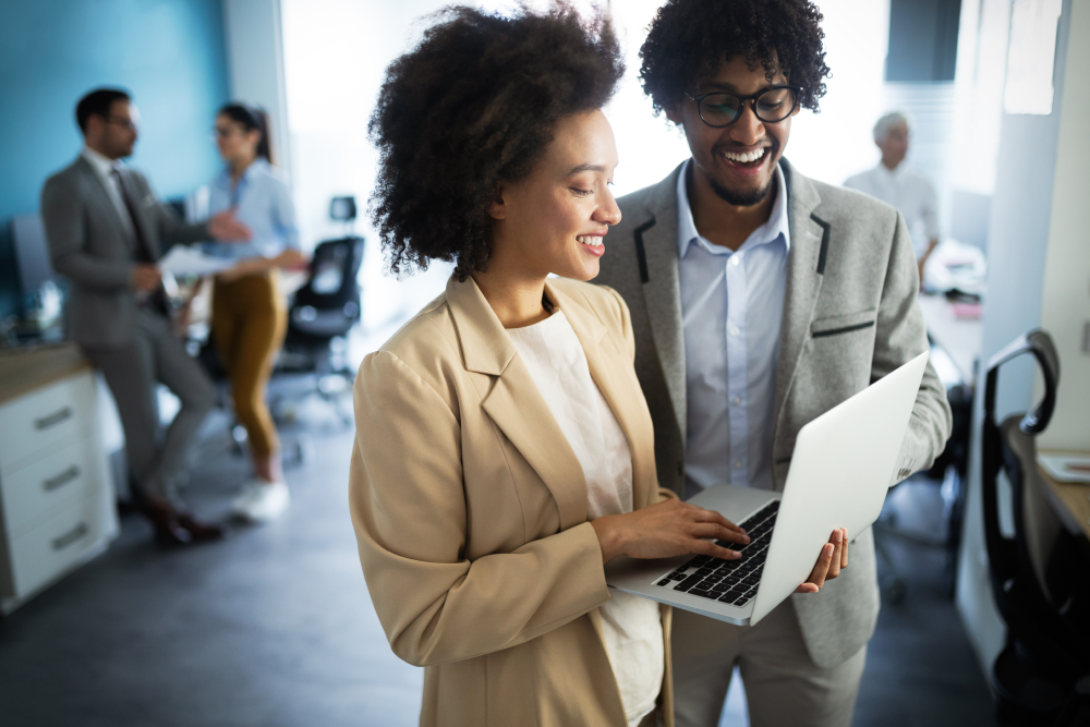 a man and woman looking at a laptop