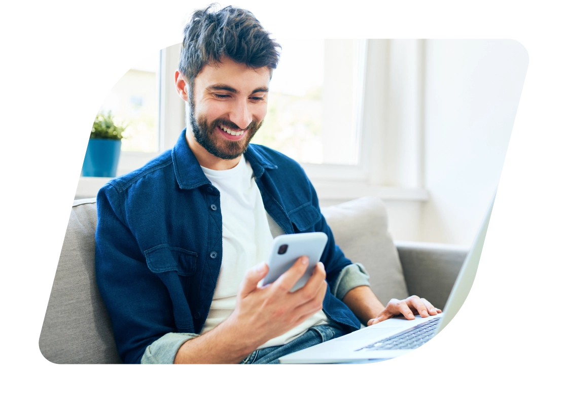 a man sitting on a couch using a laptop