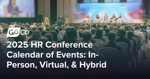 A crowd seated at a conference listening to a panel of speakers.