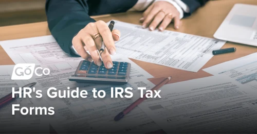 A person works on tax paperwork with the help of a calculator.