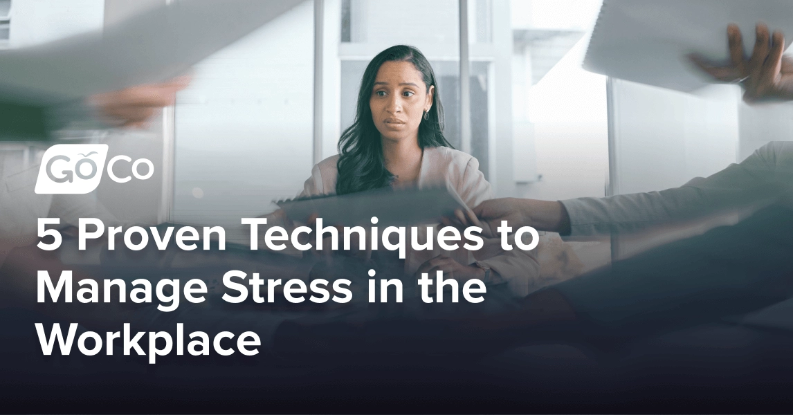 Worried businesswoman in a busy office with many people handing around paperwork.