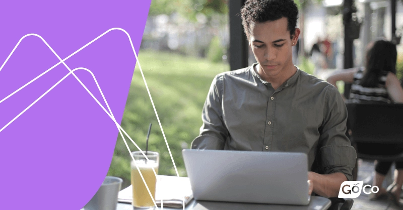 A man sitting at a table working on a laptop.