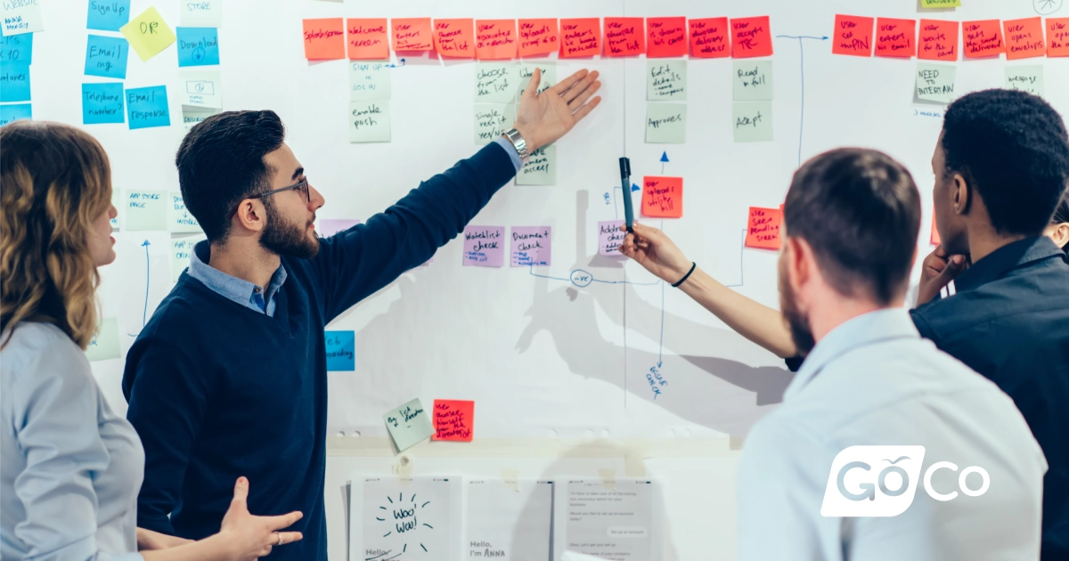 a group of people working on a whiteboard